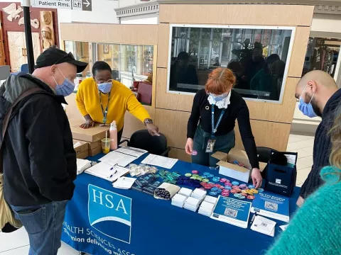 CMET member giving away swag to HSA members