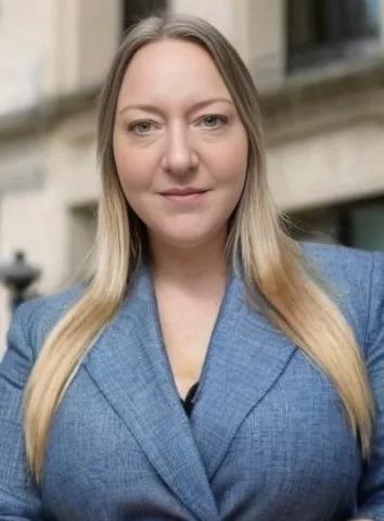 A white woman with long blonde hair wearing a medium blue blazer.